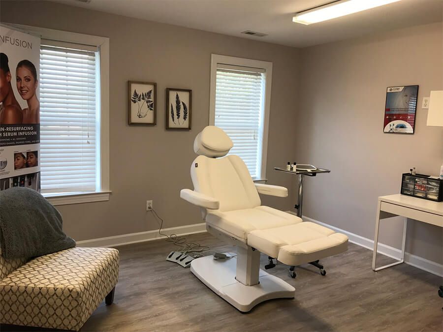 Aesthetic treatment room with medical chair and decor.