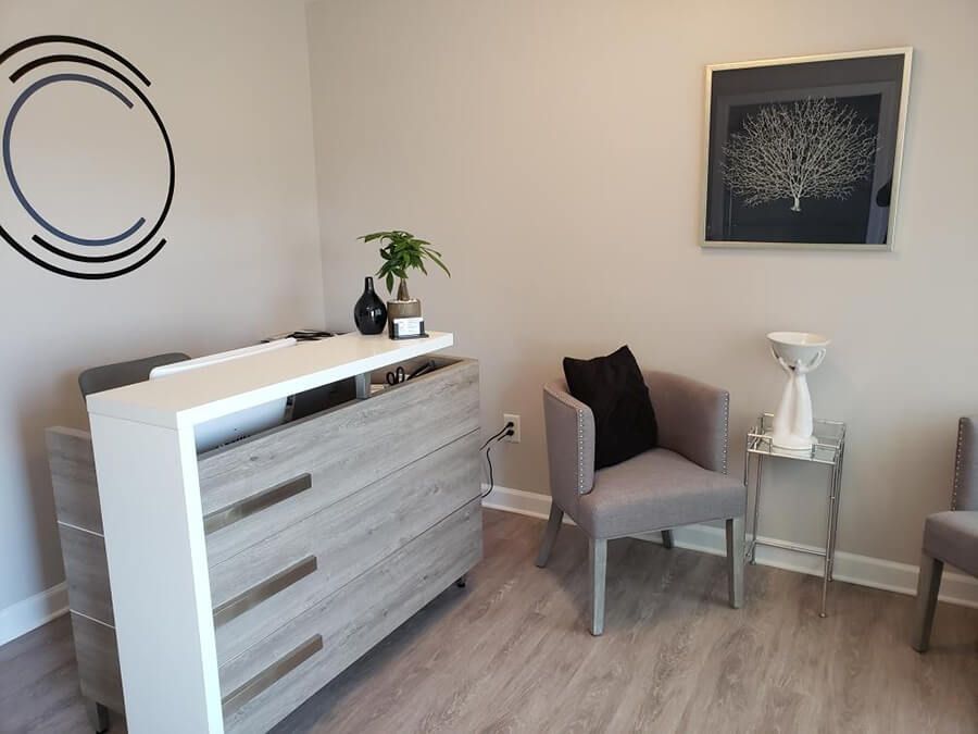 Modern reception area with gray chairs and decor.