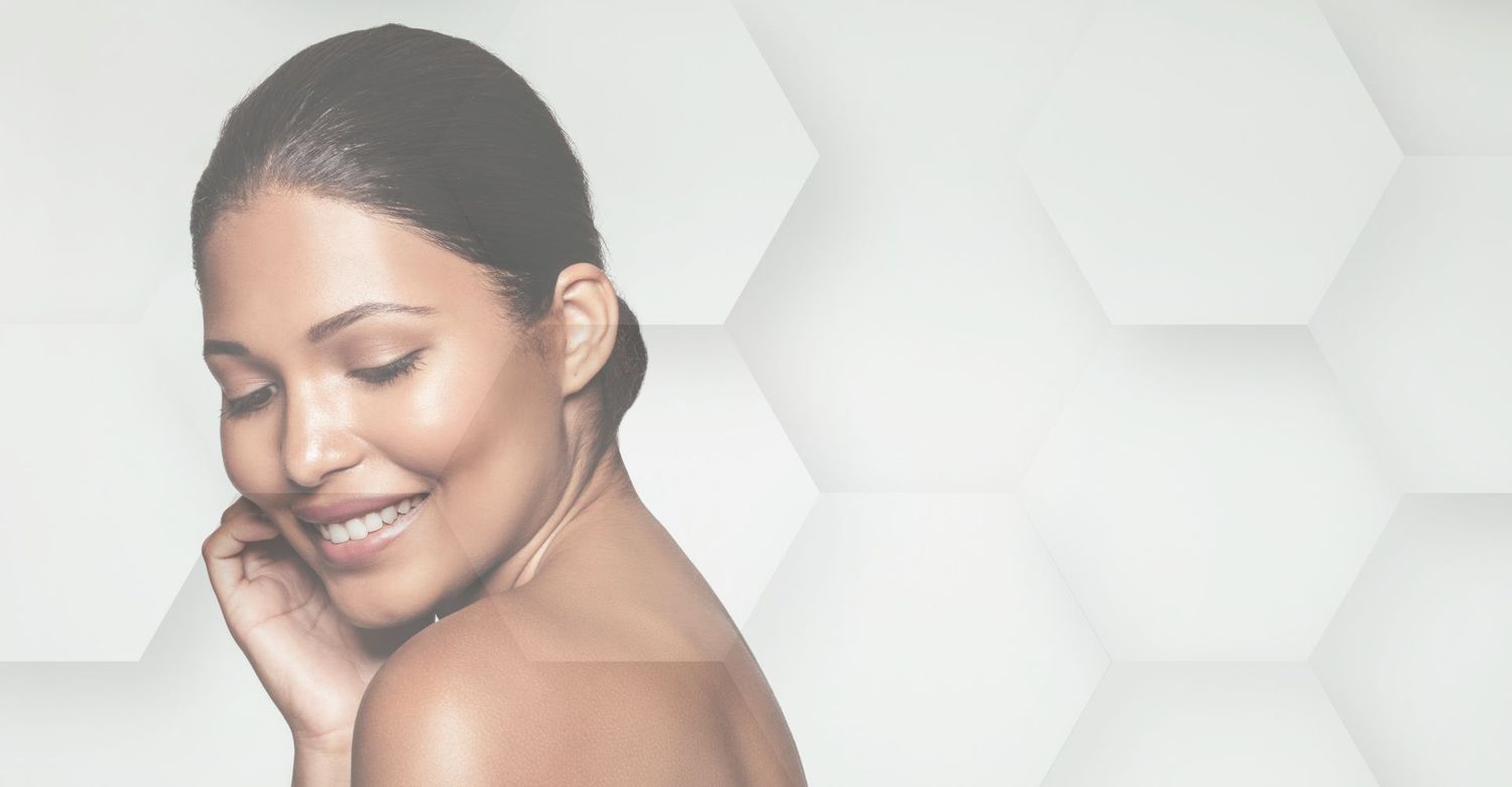 Smiling woman with smooth skin on neutral background.