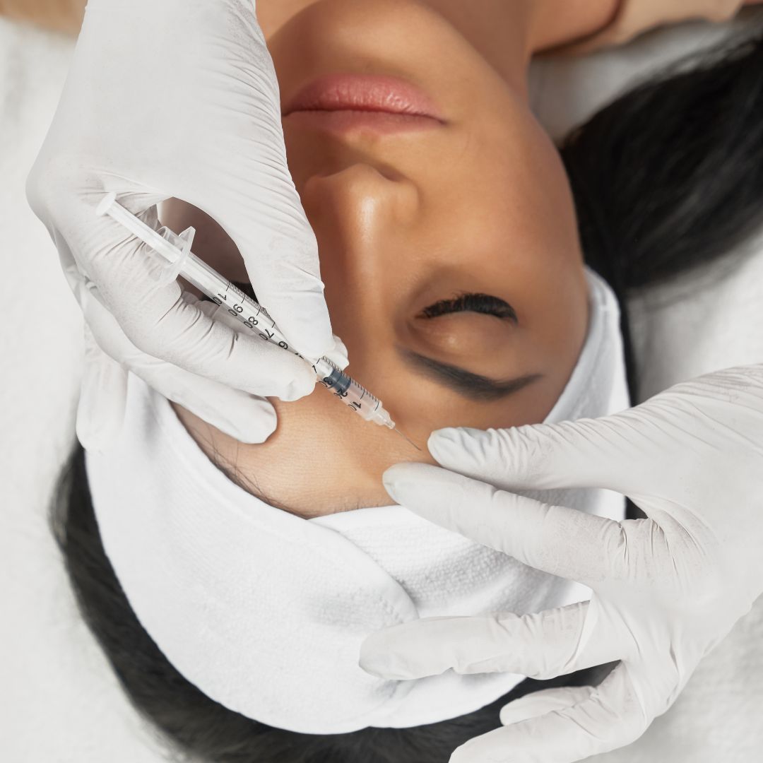 Administering a cosmetic injection to forehead.