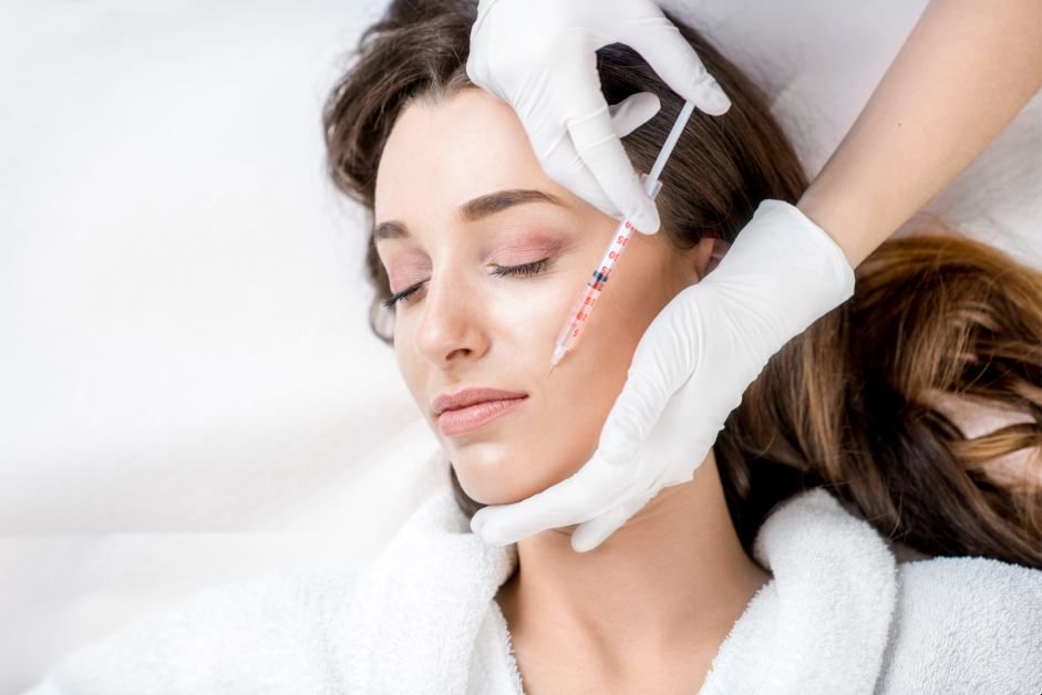 Beauty treatment with injection on woman's face.