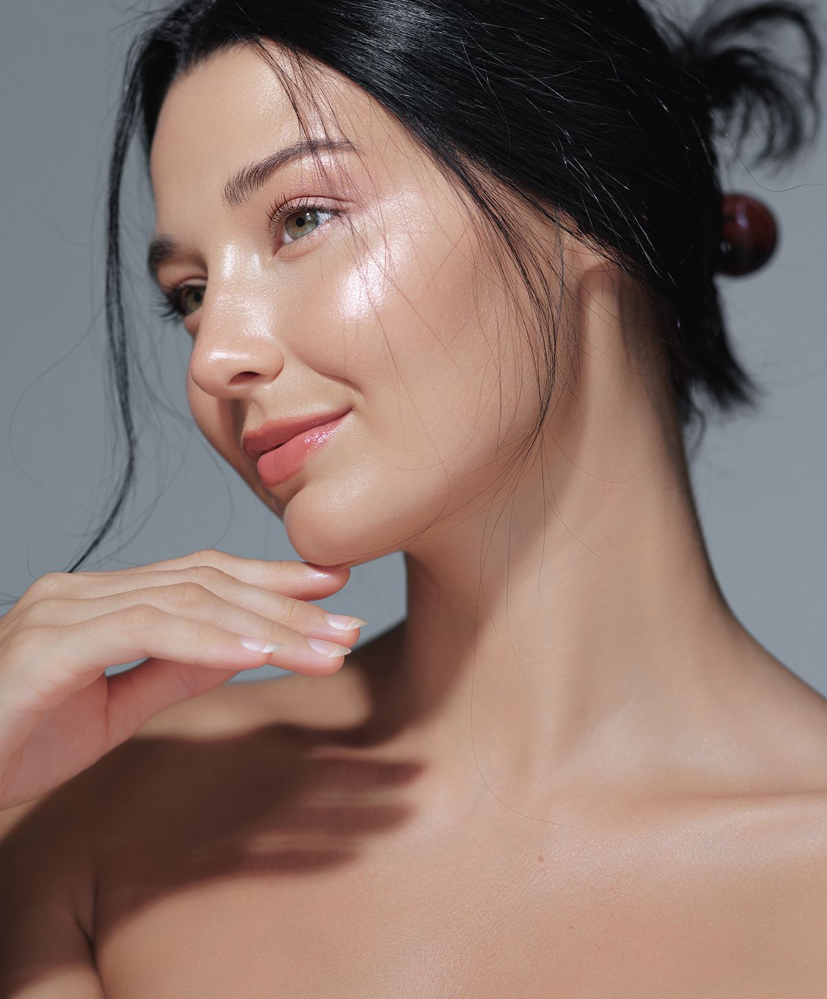 Woman in profile with glowing skin and soft light.