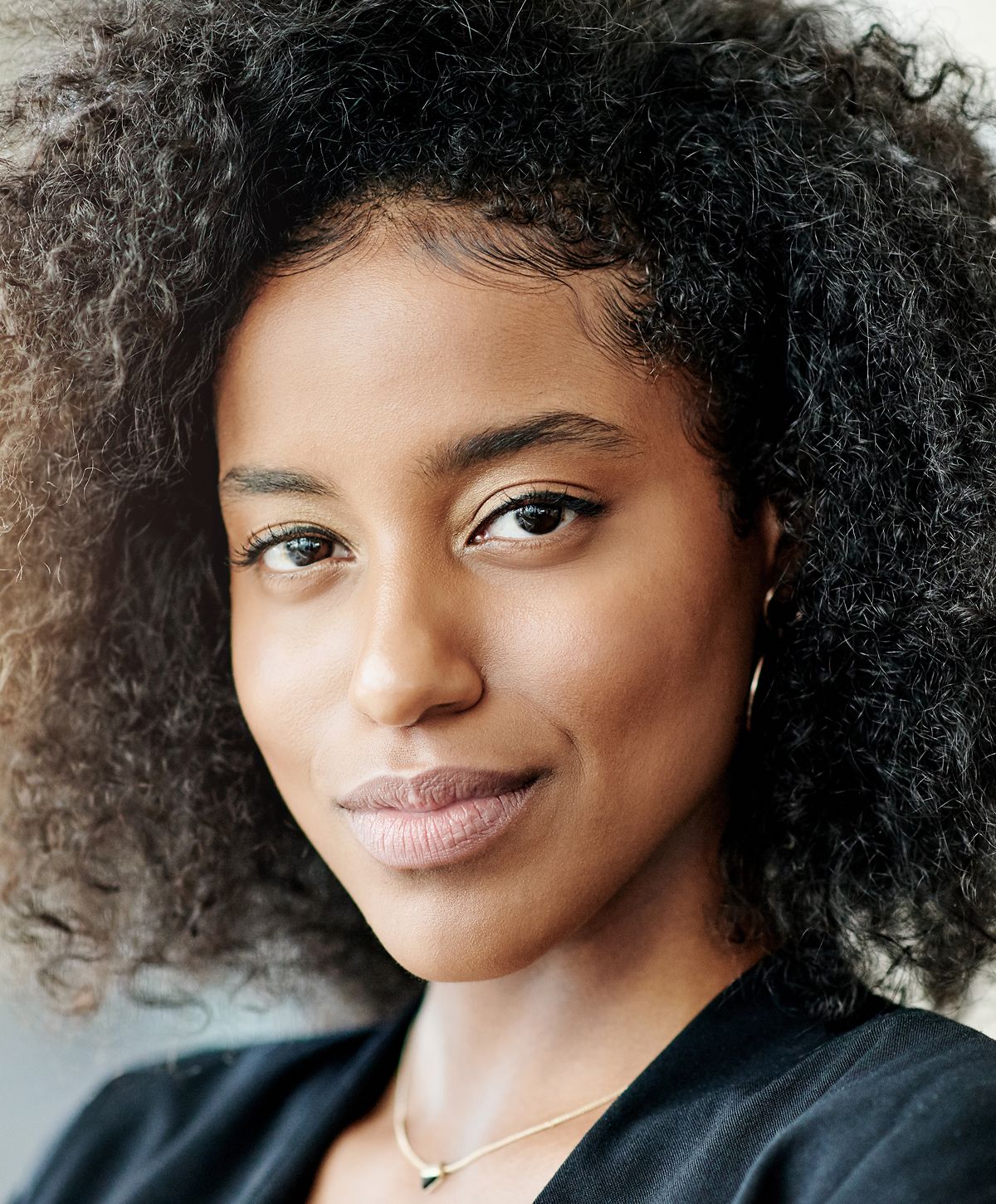 Woman with curly hair and natural makeup.