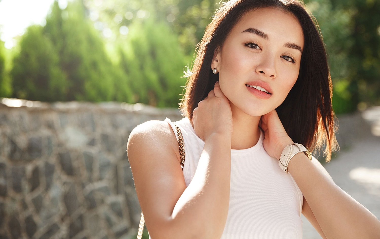 Smiling woman in casual white top outdoors.