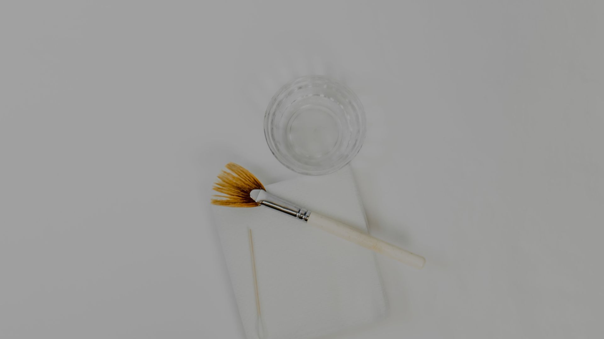Brush, water cup, and paper towel setup.