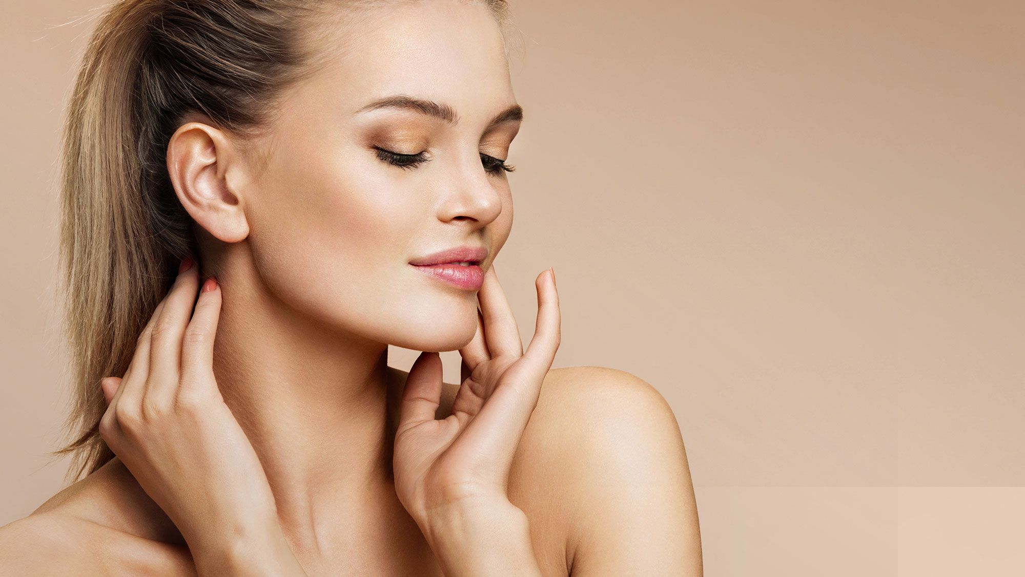 Woman gently touching her face, soft skin tone.