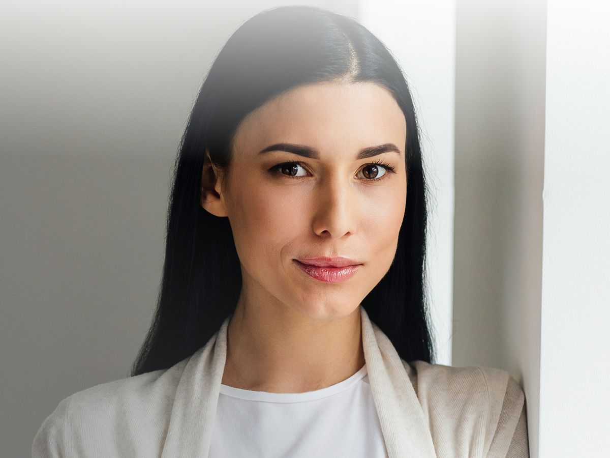Woman with long dark hair, serious expression.
