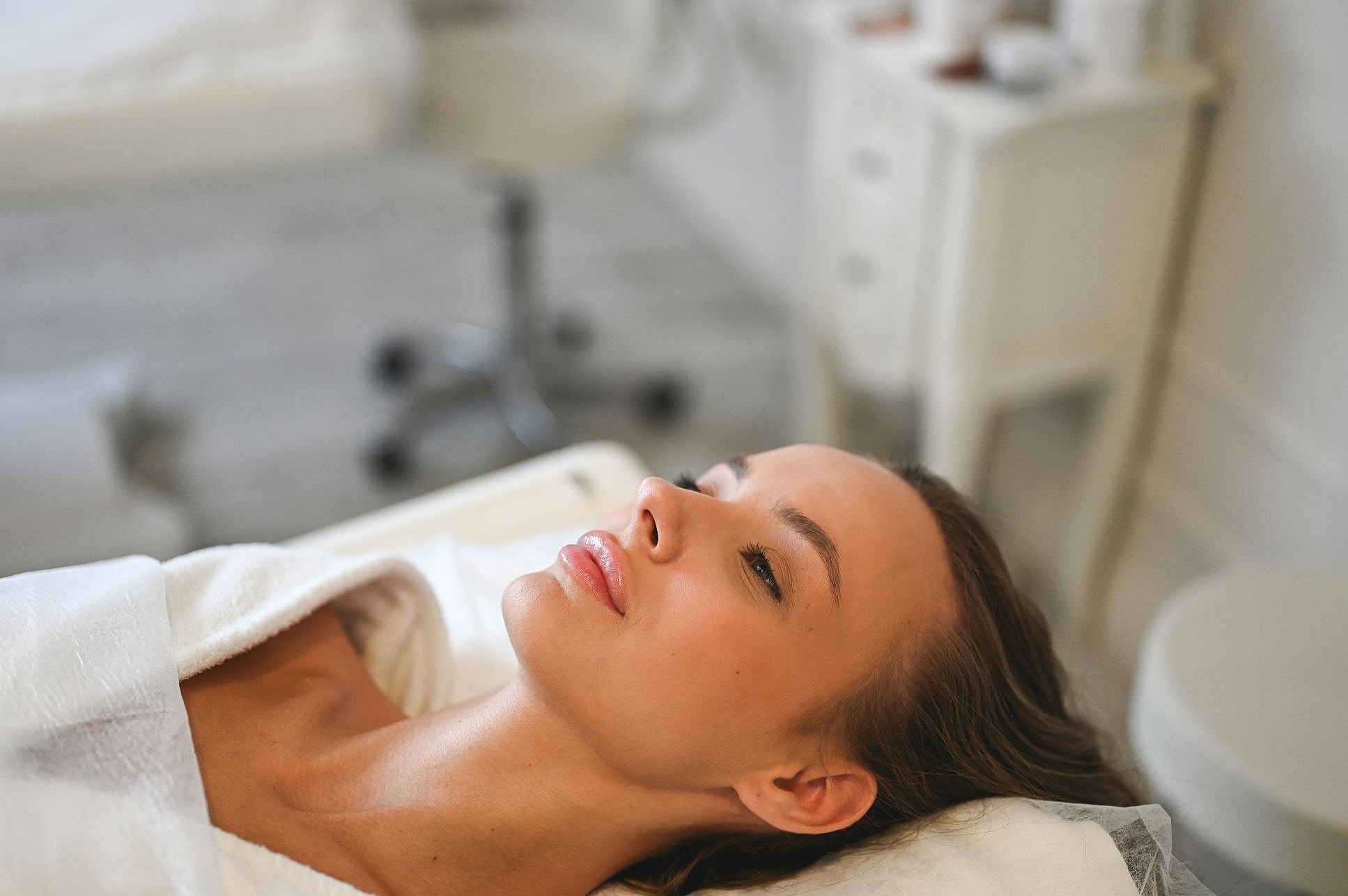 Woman relaxing during facial treatment in spa.