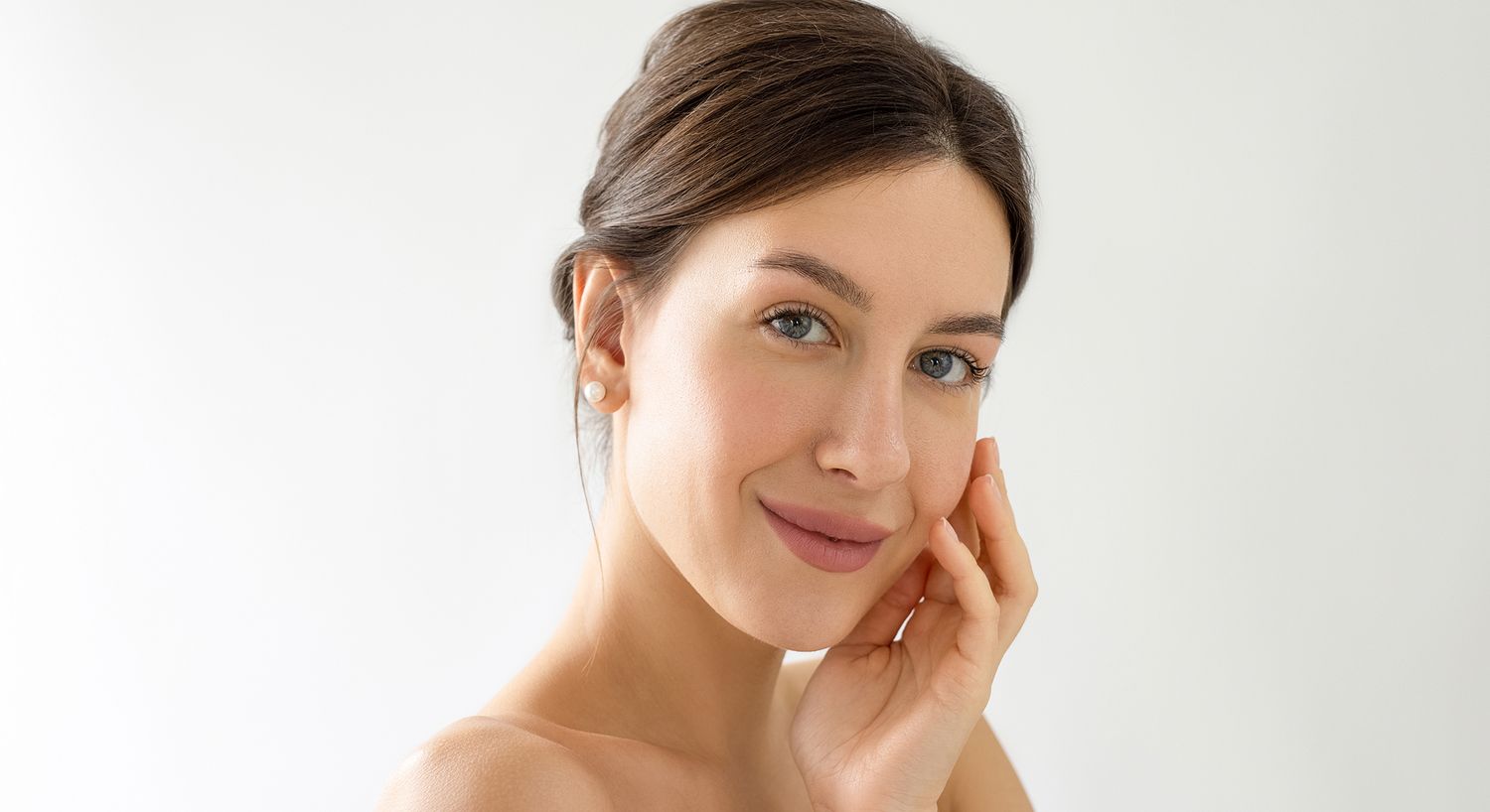 Smiling woman touching her face with elegance.